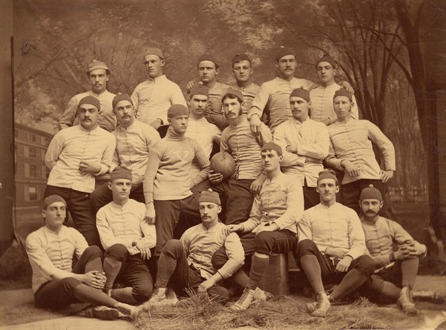 The 1879 Yale rugby team, with team captain Walter Camp (center, holding football).