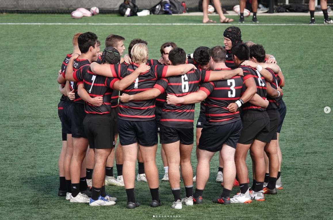 team hugs in a circle on the field