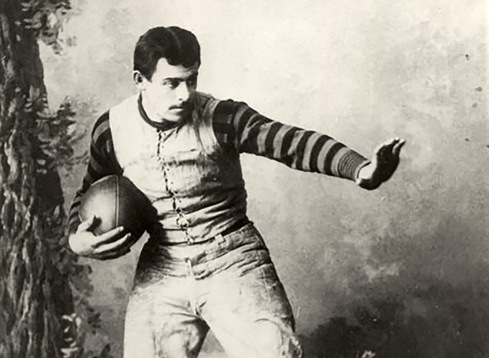 Former player and coach on the University of Pennsylvania football team strikes the Heisman pose. Penn Law alumnus, John Heisman