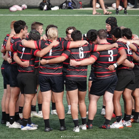 team hugs in a circle on the field