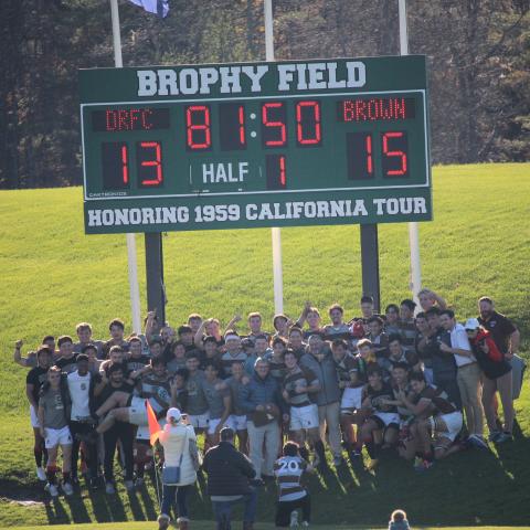 team hudles around scoreboard after victory