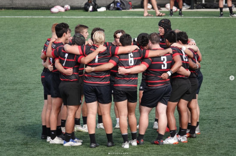 team hugs in a circle on the field