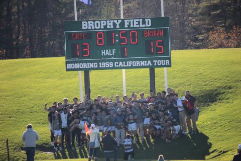 team hudles around scoreboard after victory