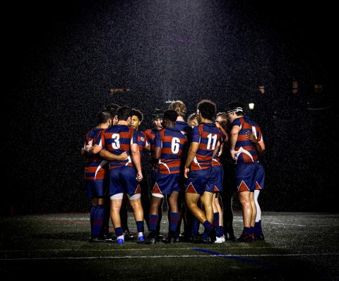 team huddle at night in rain
