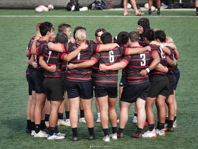 team hugs in a circle on the field