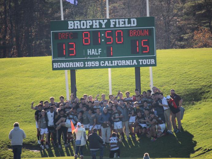 team hudles around scoreboard after victory