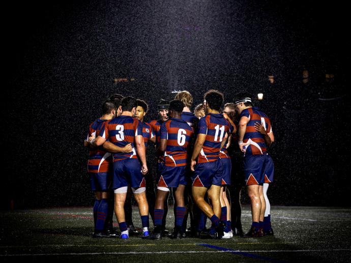 team huddle at night in rain